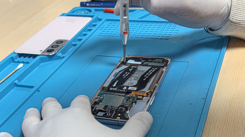 Een Samsung-telefoon wordt opengeschroefd op de blauwe werkmat